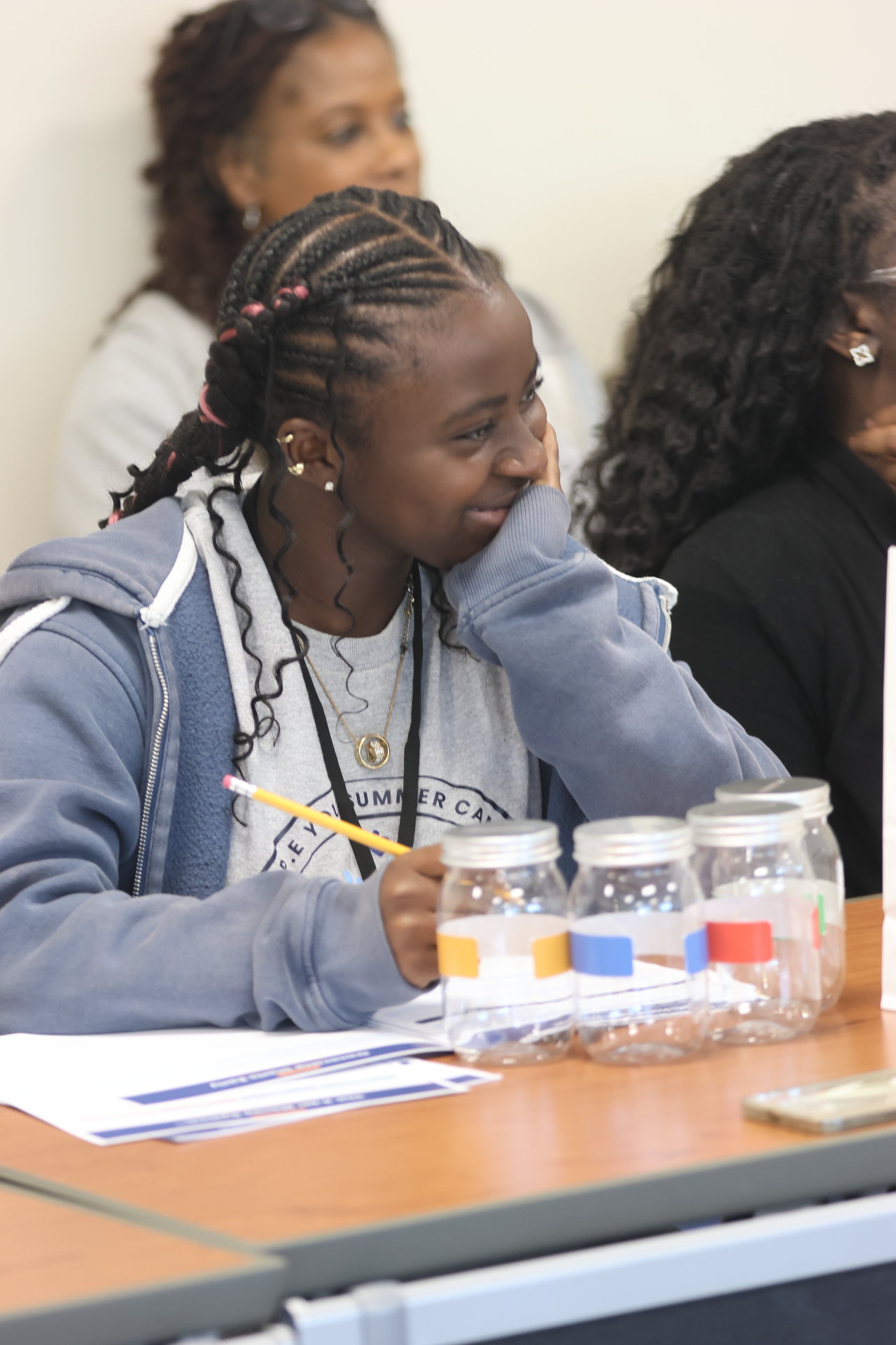 Young participant reflecting during a 4-Jar Money System™ session with labeled jars on the table
