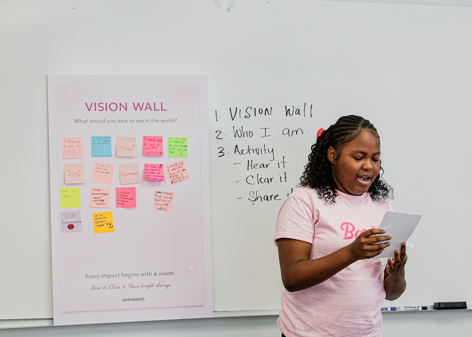 Youth participant reading her reflection alongside the Vision Wall